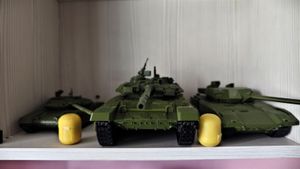 Модель танка Т-90 спереди на полке среди других моделей